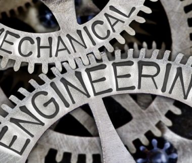 Macro photo of tooth wheel mechanism with MECHANICAL ENGINEERING letters imprinted on metal surface